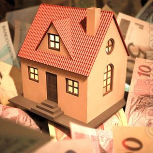 Casa e moedas representando a transformação da posse em propriedade através do usucapião
